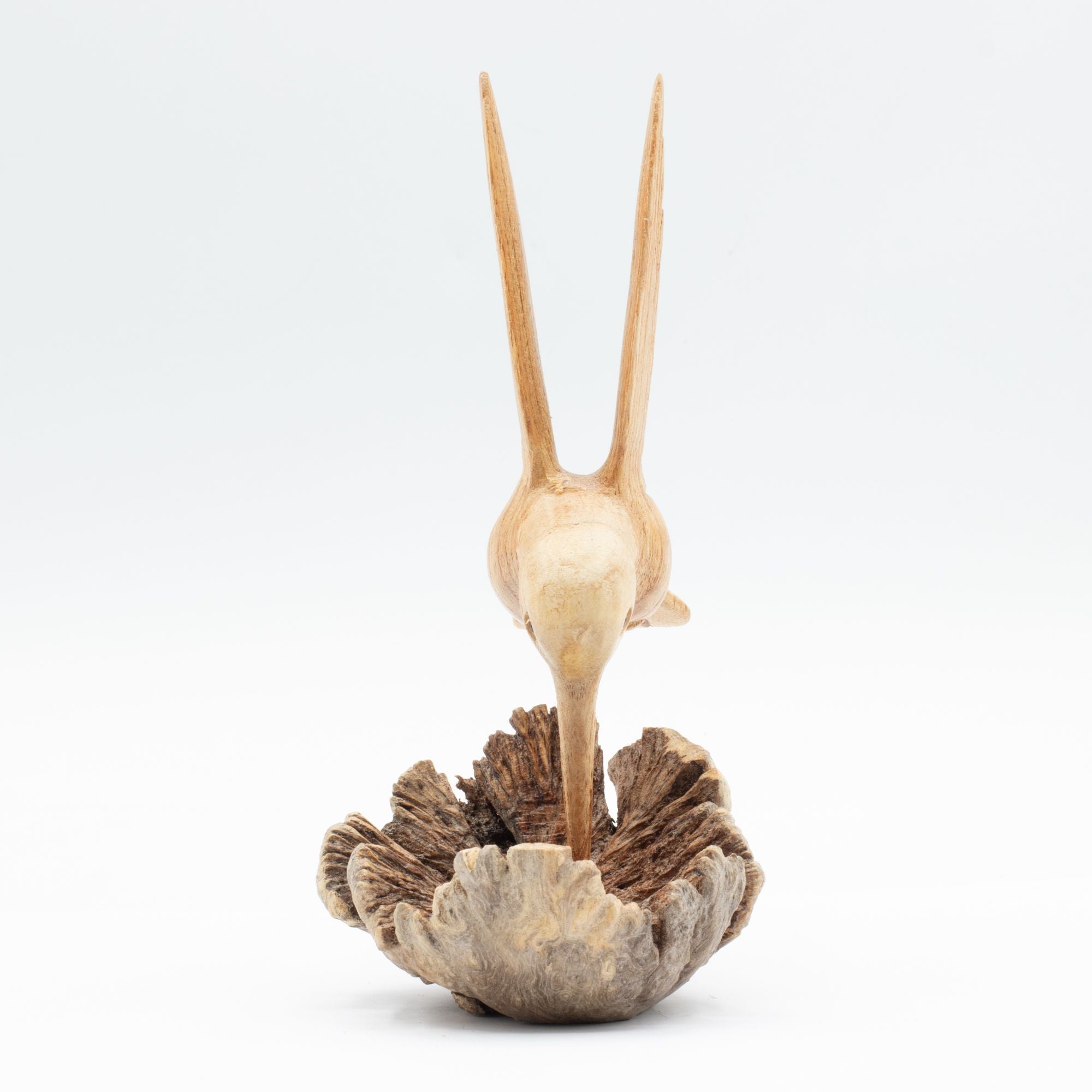 Scultura artigianale di colibrì che beve nettare da una gemma legnosa